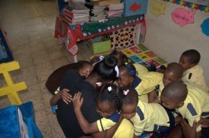 Let's hug teacher! The children at Sunrays Educational Centre show some love on Read Across Jamaica Day. (Photo: Crayons Count Facebook page) 