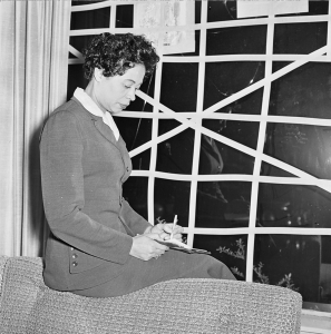 Daisy Bates at her taped-up living room window in Little Rock. Rocks were often thrown through it. (Credit: Gertrude Samuels Collection)