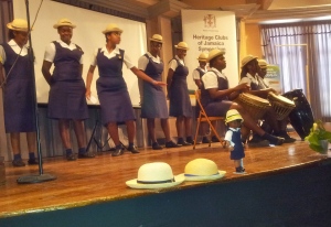 Westwood High School girls wear their trademark hats made from "jippi jappa" - the leaves of a particular palm tree. They put a little doll wearing their uniform at the front of the stage.