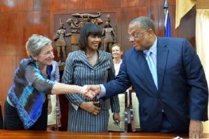 Prime Minister Portia Simpson Miller (centre) looks on as Minister of Finance and Planning, Dr Peter Phillips (right) greets Head of the European Union (EU) Delegation in Jamaica, Paola Amadei, at the signing ceremony between Jamaica and the EU, for grant funding of $11.5 billion, held at Jamaica House Friday to mark Europe Day. (Photo:JIS)