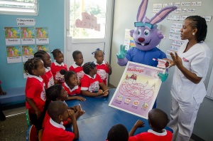 Fun with Dr. Rabbit...Dental hygienist Tamisha Spooner demonstrates proper oral care to Union Gardens Infant School student with help from Colgate’s mascot, Dr. Rabbit. The occasion was the launch of Colgate’s Mobile Dental Unit on April 7. The Mobile Dental Unit is a critical component of Colgate’s “Bright Smiles, Bright Futures” school programme which provides education and oral care for approximately 150,000 children aged 6 to years annually island-wide.